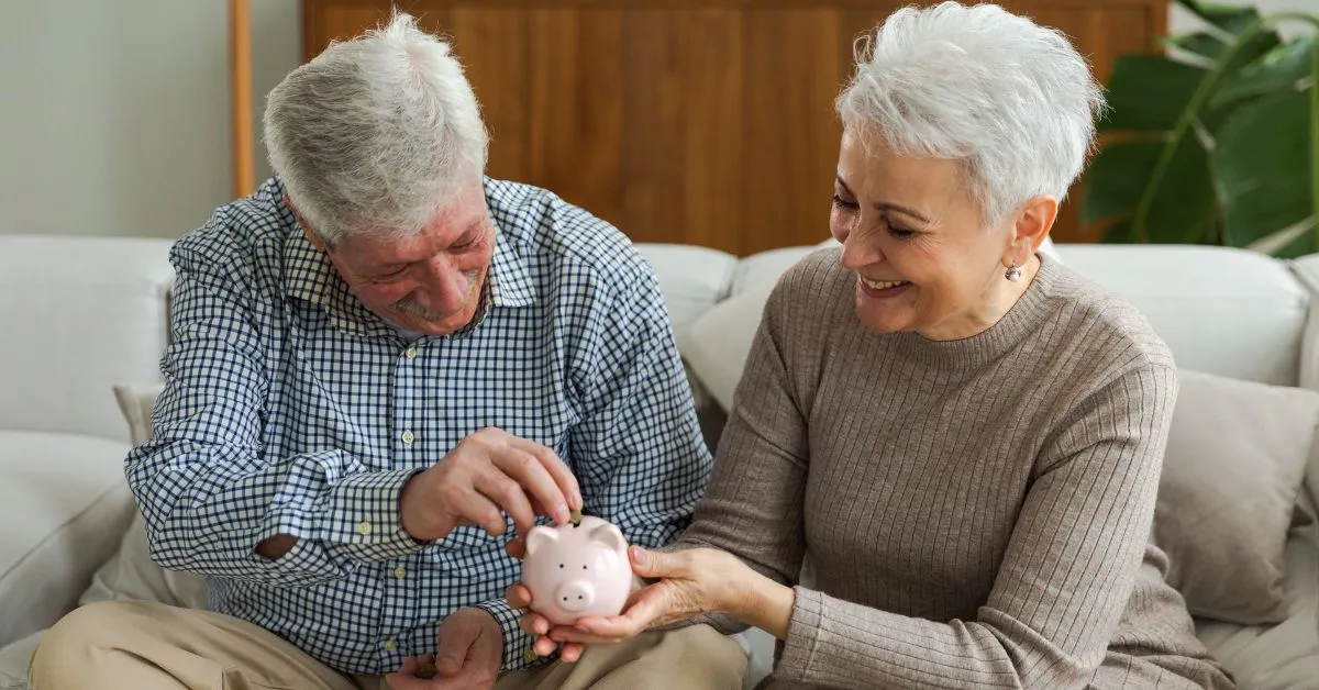 Casal idoso sorrindo e colocando moedas em um cofrinho, representando a dúvida sobre o LOAS e o direito ao décimo terceiro salário.