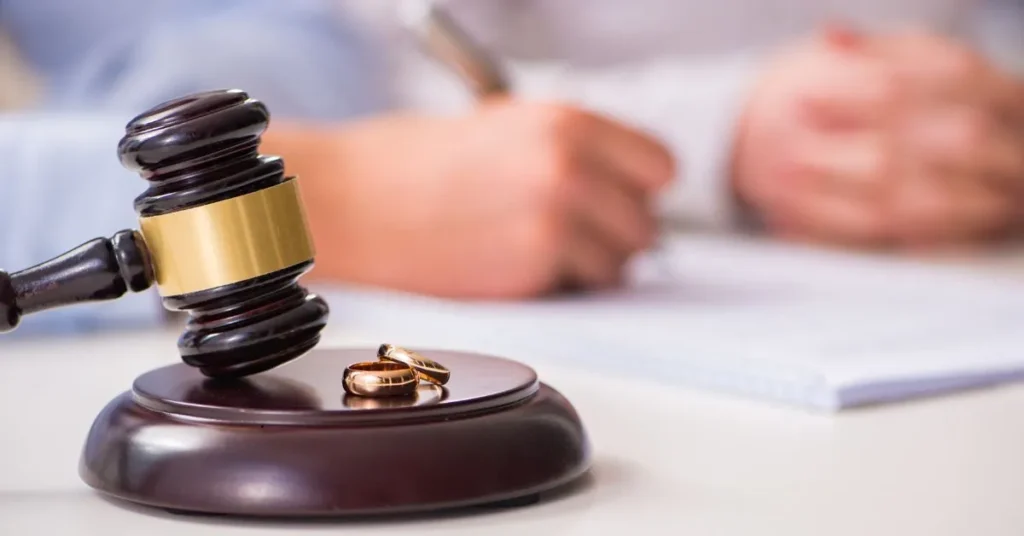 Mudança de regime de bens no casamento representada por martelo de juiz e alianças sobre a mesa