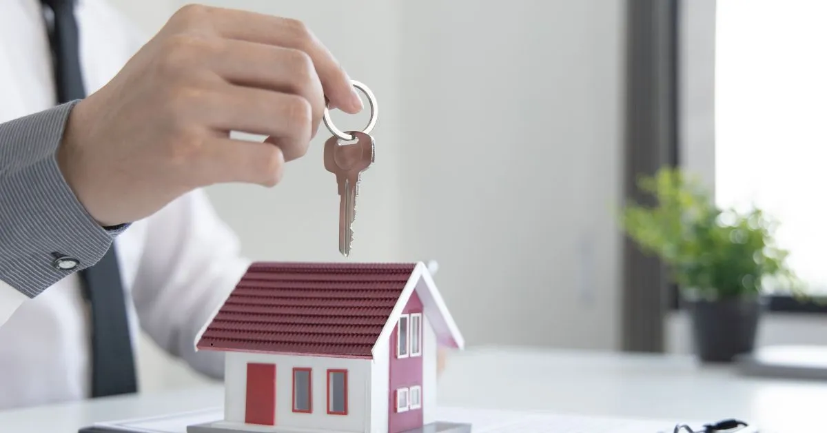 Chave sobre maquete de casa simbolizando casa financiada no divórcio
