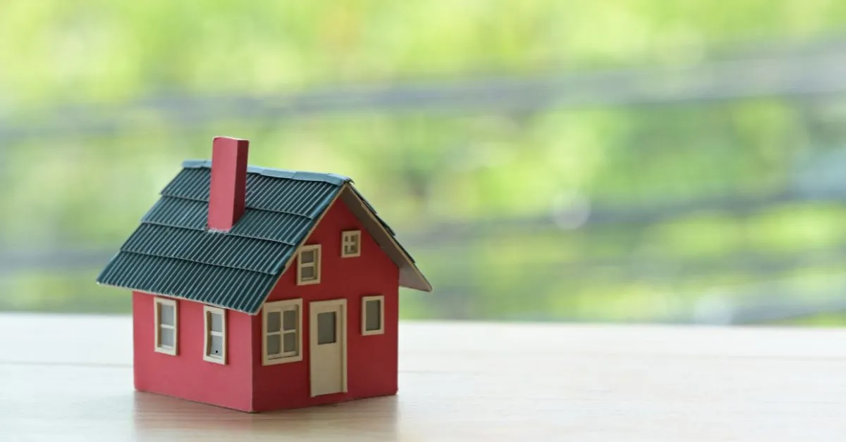 Miniatura de casa vermelha simbolizando herança de imóvel financiado em inventário