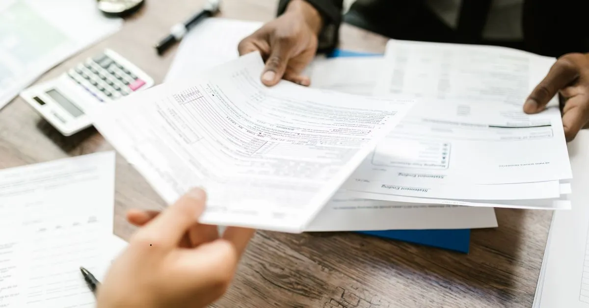 Pessoas analisando documentos e calculadora sobre partilha de bens