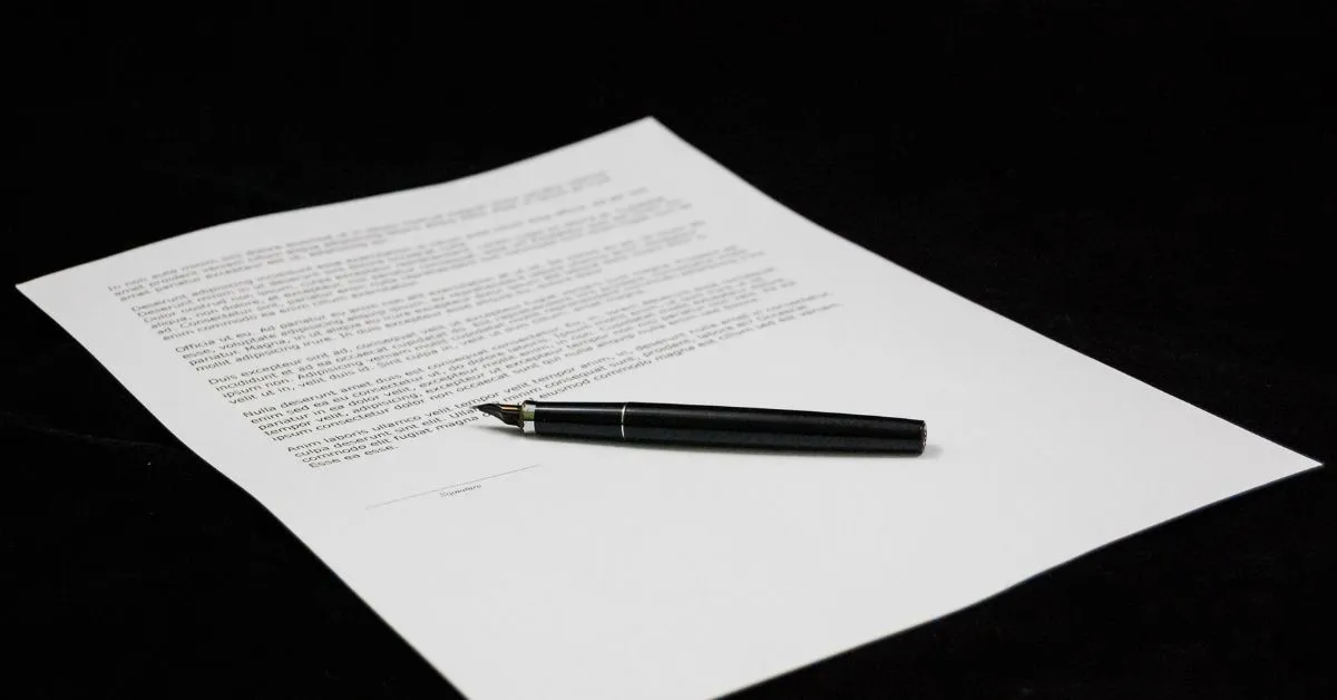 Herança com Testamento: documento jurídico com caneta sobre a assinatura, ilustrando partilha e limites legais