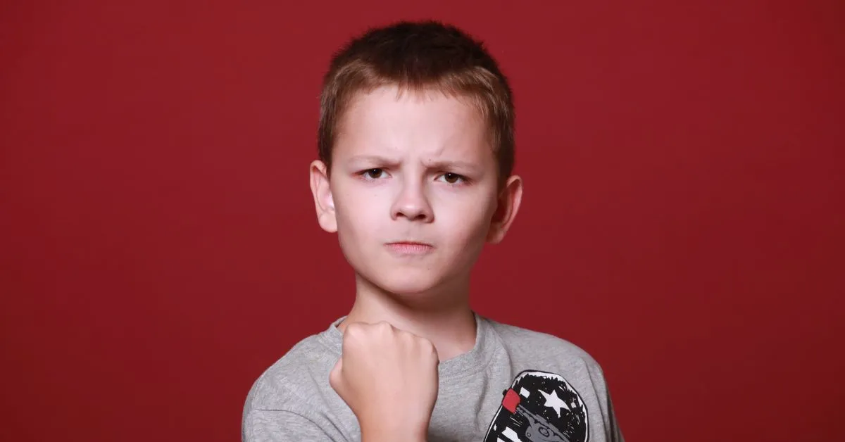 Alienação parental e medidas protetivas: criança com expressão séria e punho cerrado, simbolizando conflito familiar
