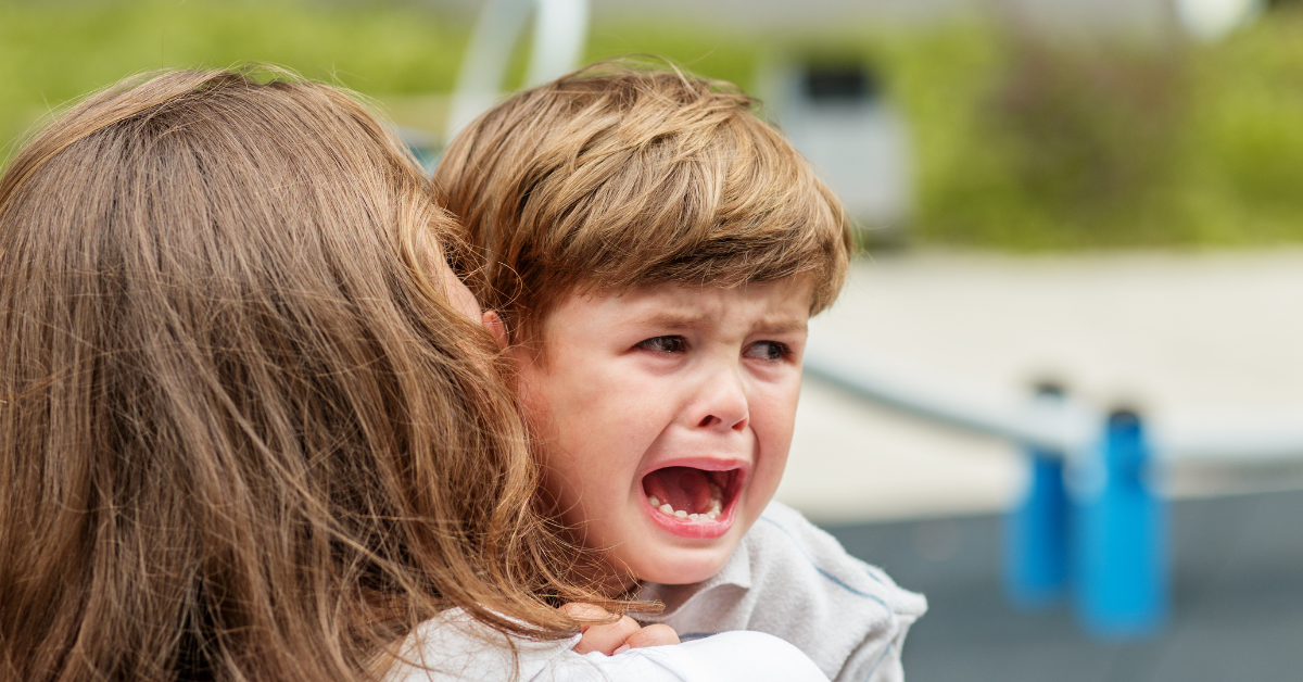 Criança chorando no colo da mãe, representando sofrimento causado por falsas alegações de abuso e alienação parental.