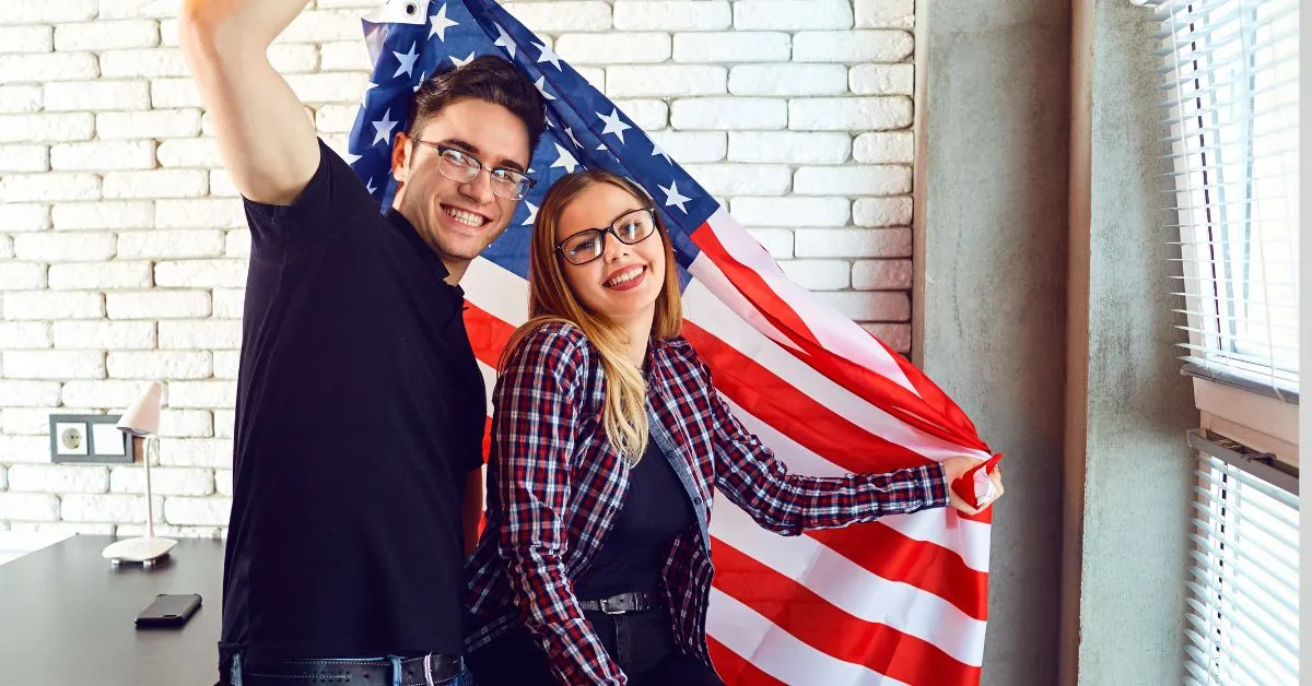 casal sorridente com bandeira dos Estados Unidos simbolizando união estável com estrangeiro