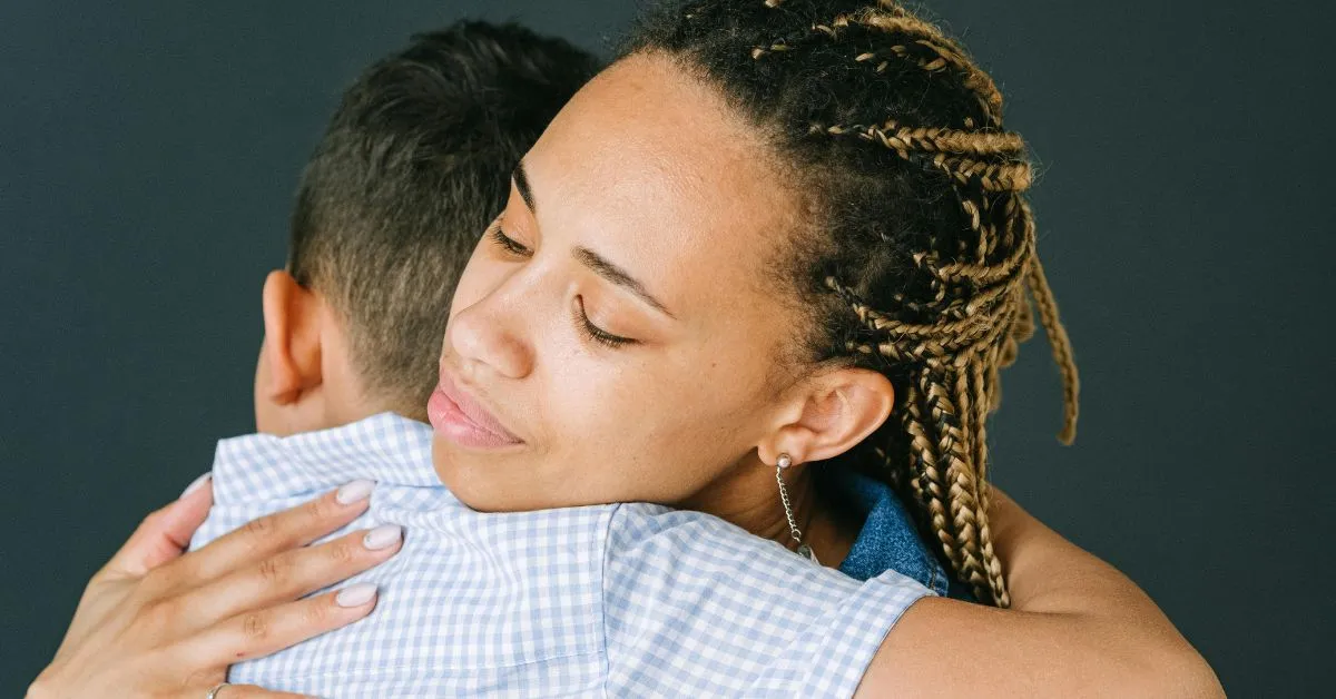 Mulher abraçando uma criança, representando o amor e vínculo na adoção por pessoa solteira.