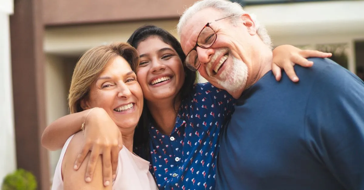 avós abraçando neta sorridente representando vínculo afetivo familiar