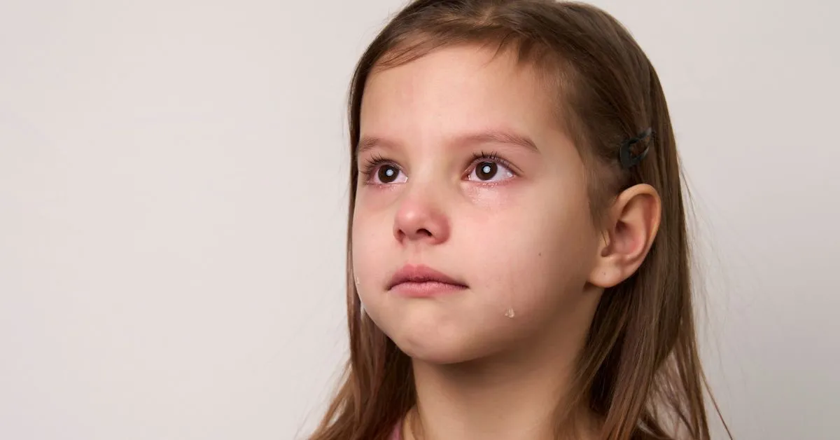 Criança triste com lágrimas no rosto, representando abandono afetivo em disputa de guarda.