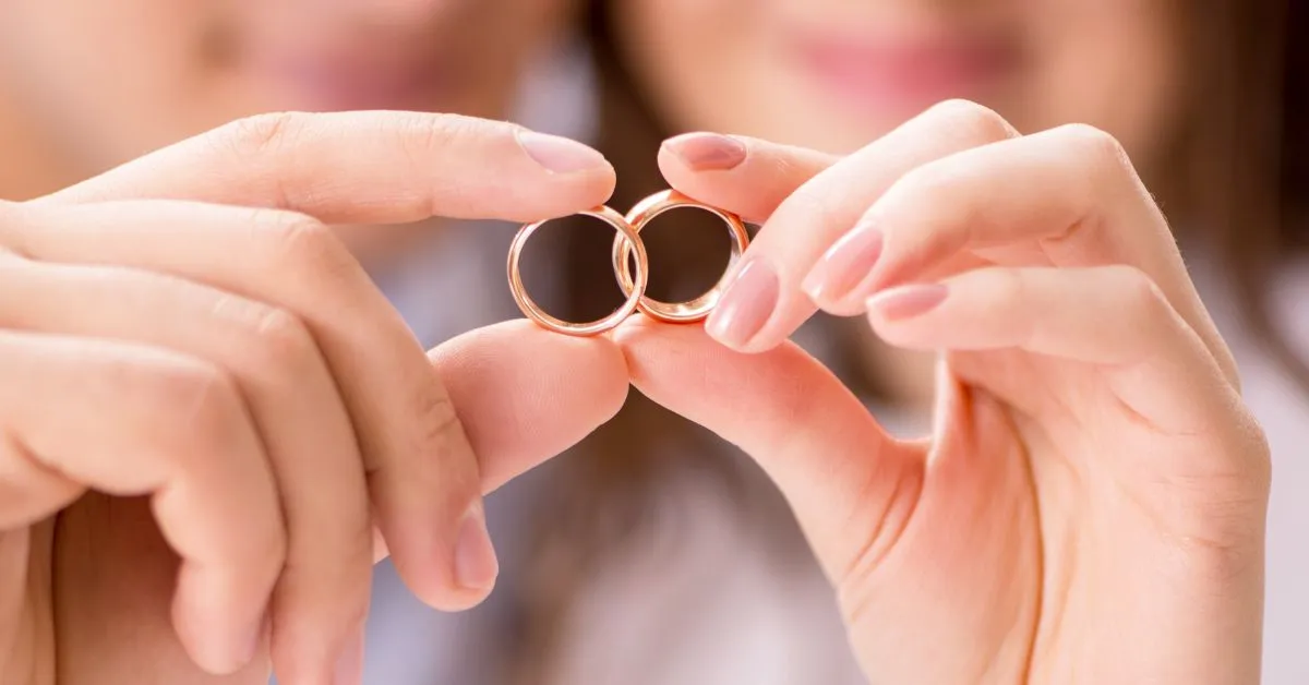 Casal segurando alianças simbolizando casamento e proteção patrimonial no regime de bens para empreendedores.