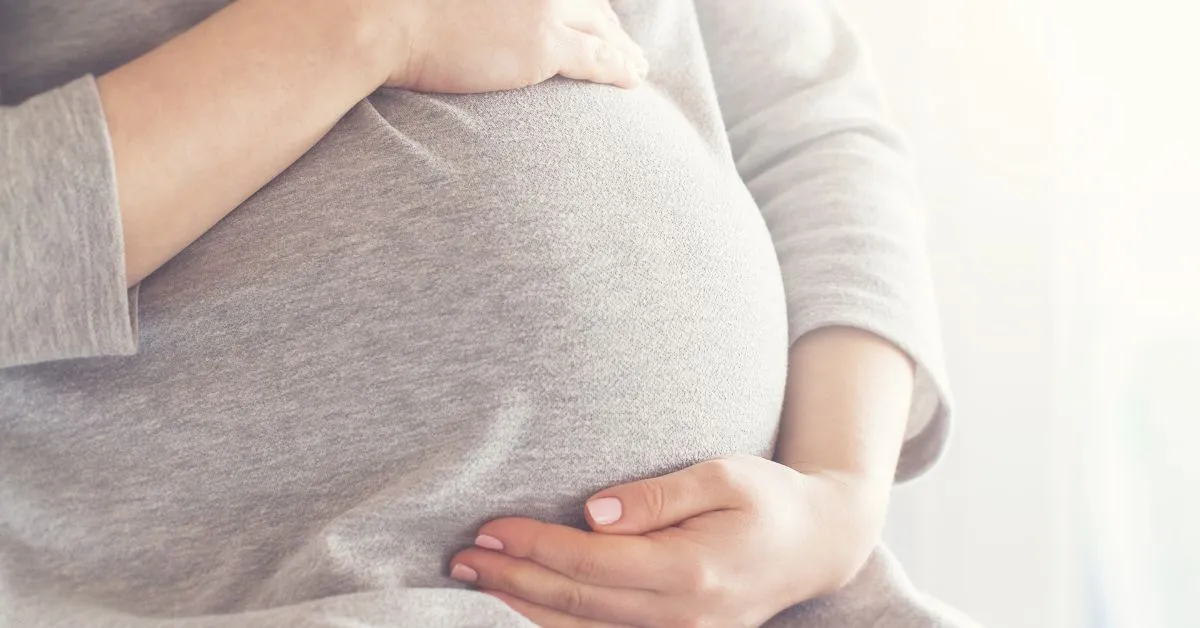 Gestante com as mãos sobre a barriga representando os direitos na gravidez durante a união estável.