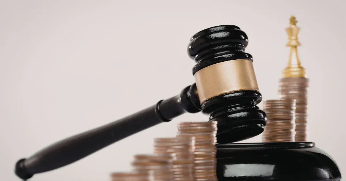 Martelo de juiz sobre pilhas de moedas representando decisões judiciais relacionadas à guarda compartilhada e moradia alternada