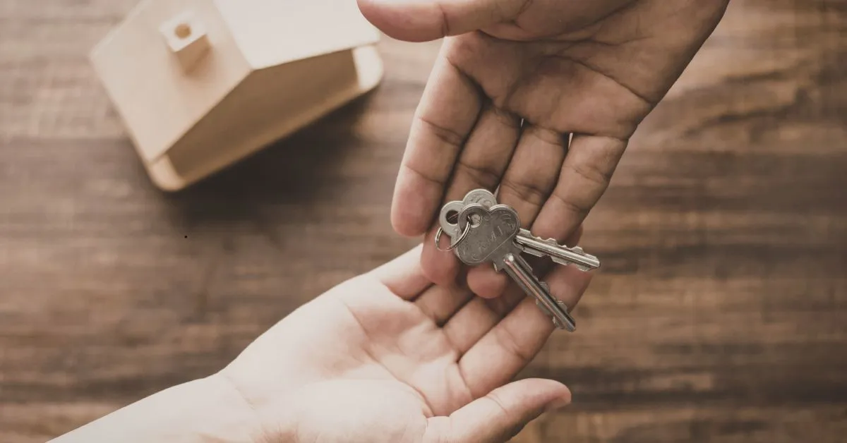 Entrega de chaves de imóvel simbolizando partilha de bens e discussão sobre imóvel comprado antes do casamento